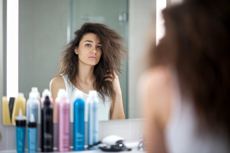 femme-cheveux-frises-miroir-produits